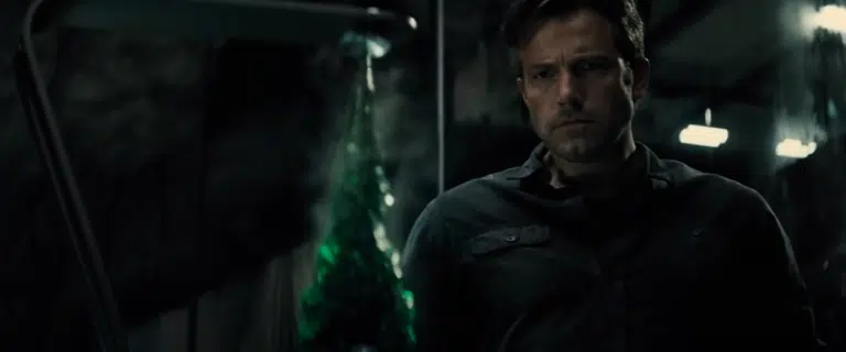 Bruce Wayne observes the kryptonite tip of the spear he's engineered
